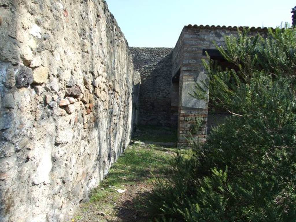 II.1.12 Pompeii. March 2009. Looking east along the north wall to sacellum, and area of storeroom. According to Jashemski, to the left (north) of the sacellum were 2 storerooms. To the right (south) were 2 roughly furnished rooms in which various cult objects were stored
(see photos of rooms on east side of peristyle, above and in Pt.2).
Among the objects found in the rooms off of the sacellum were two almost life-sized bronze right hands. Hands such as these were associated with the worship of Sabazius. Various bronze as well as terracotta lamps: a bronze statuette of a youth: and a small bronze dog were also found. Near the altar were 2 unusual, squat terracotta vases which had a little bowl attached to the rim above each handle. See Jashemski, W. F., 1993. The Gardens of Pompeii, Volume II: Appendices. New York: Caratzas. (p.76)