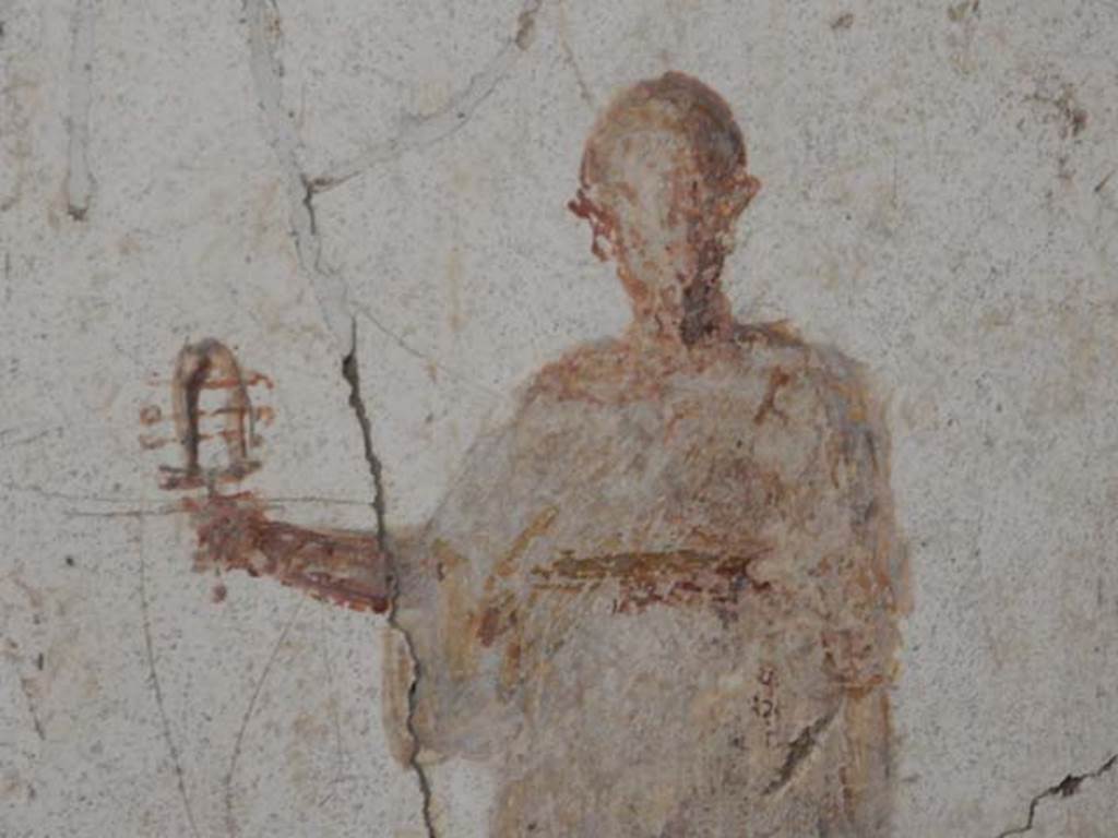 II.2.2 Pompeii. May 2016. Room “f”, detail of figure of priest of Isis from west end of south wall. Photo courtesy of Buzz Ferebee.