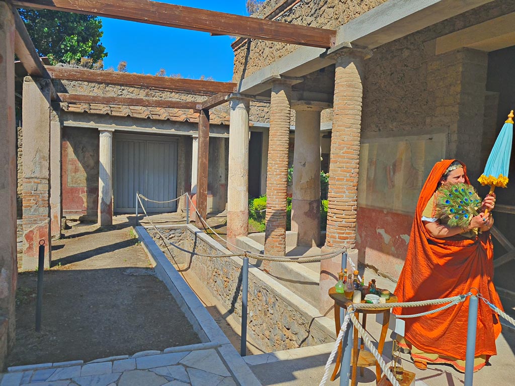 II.2.2 Pompeii. 8th June 2024.
Room “i”, looking west along upper euripus, with actor playing the part of an ancient pompeian. Photo courtesy of Giuseppe Ciaramella.
Historical reconstruction entitled L’altra Pompei prende vita (The other Pompeii comes to life).