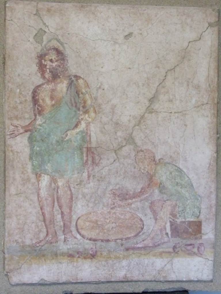 II.3.8 Pompeii. Painting of a God, possibly Vulcanus or Hephaistos, and potter at his wheel. found on the outside of the south-west corner of the shop. SAP Inventory number 21631.