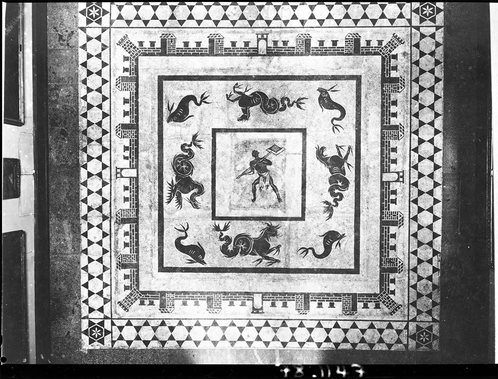 II.4.6 Pompeii. Black and white mosaic showing a furnaceman and a marine scene set in floor of Naples Museum.
DAIR 78.1147. Photo © Deutsches Archäologisches Institut, Abteilung Rom, Arkiv.
According to Marietta de Vos, this was provenanced from the baths of the Praedia di Julia Felix and is now in the floor of Naples Archaeological Museum, piano nobile, giro interno, Sala III, pavimento.
See Dell’Orto, L. F. (ed), 1993. Ercolano 1738-1988: 250 anni di ricerca archeologica: Atti del Convegno internazionale. SAP Monografie 6, p. 115, pl. XXII.
There is a photo of a mosaic with a similar castellated pattern (but with a different centre) in VI.1.7/25, which presumably would have been found a few years later, after this one. The mosaic would have been seen in Gli Ornati (pt.2.1808, and also 1838).
See Gli ornati delle pareti ed i pavimenti delle stanze dell'antica Pompei incisi in rame: 1808 and 1838, no. 41.