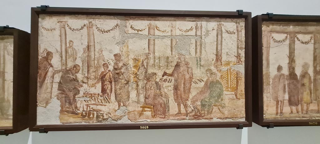 II.4.3 Pompeii. April 2023. Paintings of the Forum frieze, on display in “Campania Romana” gallery in Naples Archaeological Museum.
In centre (inv. 9069) – Vendita di attrezzi da lavoro e di scarpe. (Sale of work tools and shoes). Photo courtesy of Giuseppe Ciaramella.