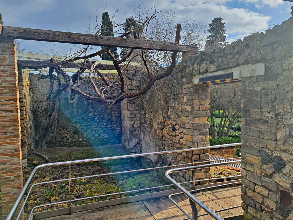 II.4.6 Pompeii. March 2024.
Looking east at south end of niches, with doorway into garden area, on right. Photo courtesy of Giuseppe Ciaramella.