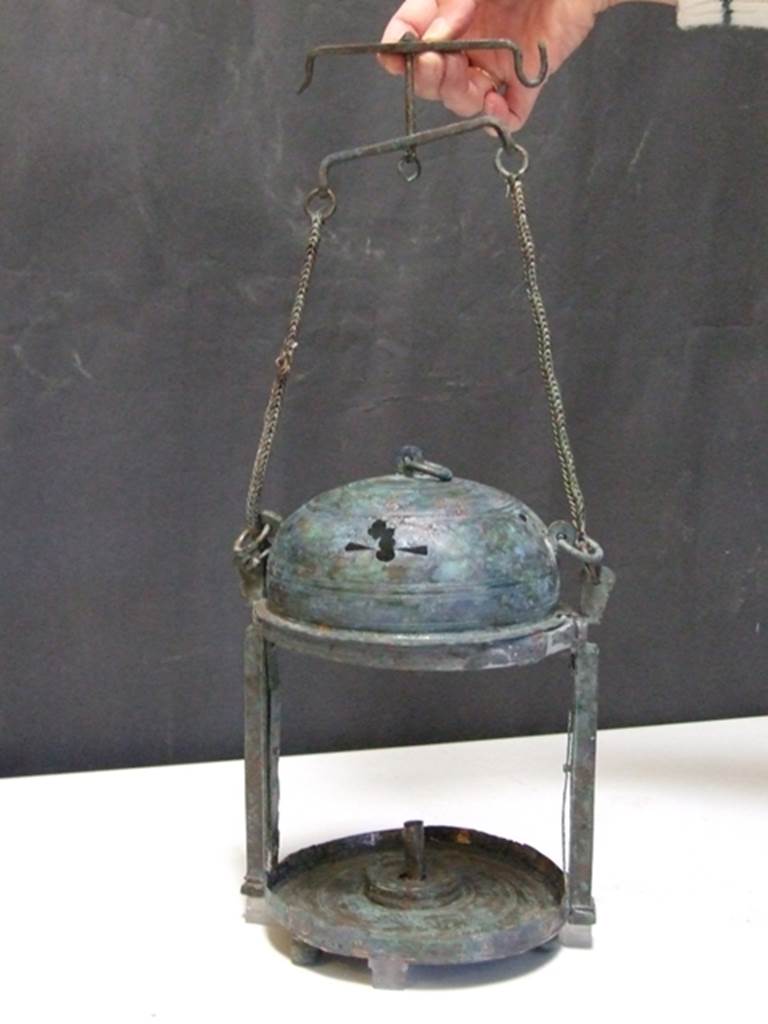 II.4.8 Pompeii. Found in 1934. Small room or stall to south of entrance. Bronze lantern. SAP inventory number 5798. The inventory card says it was found in the first room west side, vicolo crossing Via Abbondanza. �Primo vano lato O. vicolo trasversale V. Abbondanza�. According to Parslow, �In a small room near this entrance [II.4.8] the excavators came across two large bronze lanterns which originally may have been suspended by their chains from the ceiling joists, since they were found near the level of the roof�. He also identifies these with SAP inventory numbers 5798 and 5816. See Parslow, C., 1988. Rivista di studi pompeiani II. Roma: L�Erma di Bretschneider. (pp. 37).