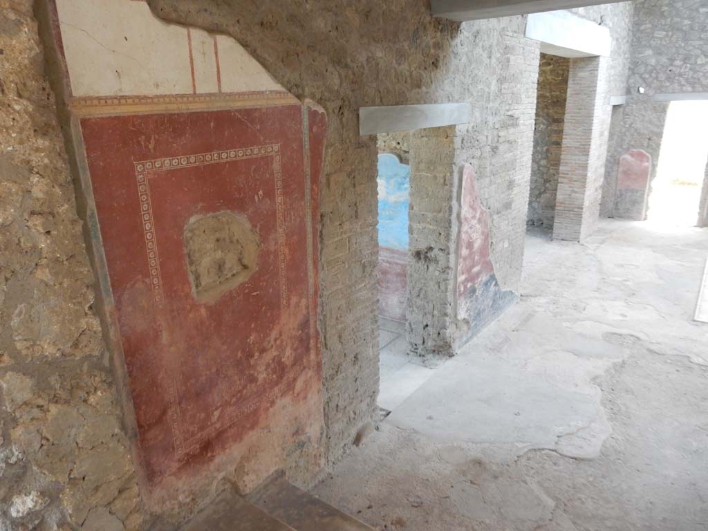 II.4.10 Pompeii. June 2019. Looking south along east wall of atrium, from steps leading from west portico.
In the centre is the doorway to the biclinium, followed by wide doorway to the tablinum.
In the south-east corner, upper right, is a small doorway to a cubiculum which then leads into a second bedroom, followed by a doorway in the south wall. Photo courtesy of Buzz Ferebee.