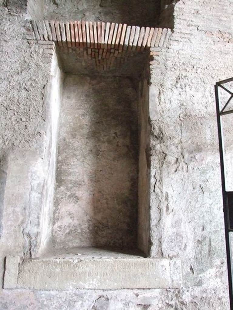 II.6 Pompeii. December 2006. Large rectangular niche, on west side of corridor in Amphitheatre. One of two inscriptions to father and son Cuspius Pansa. They restored the Amphitheatre at their own expense after the earthquake of AD62.