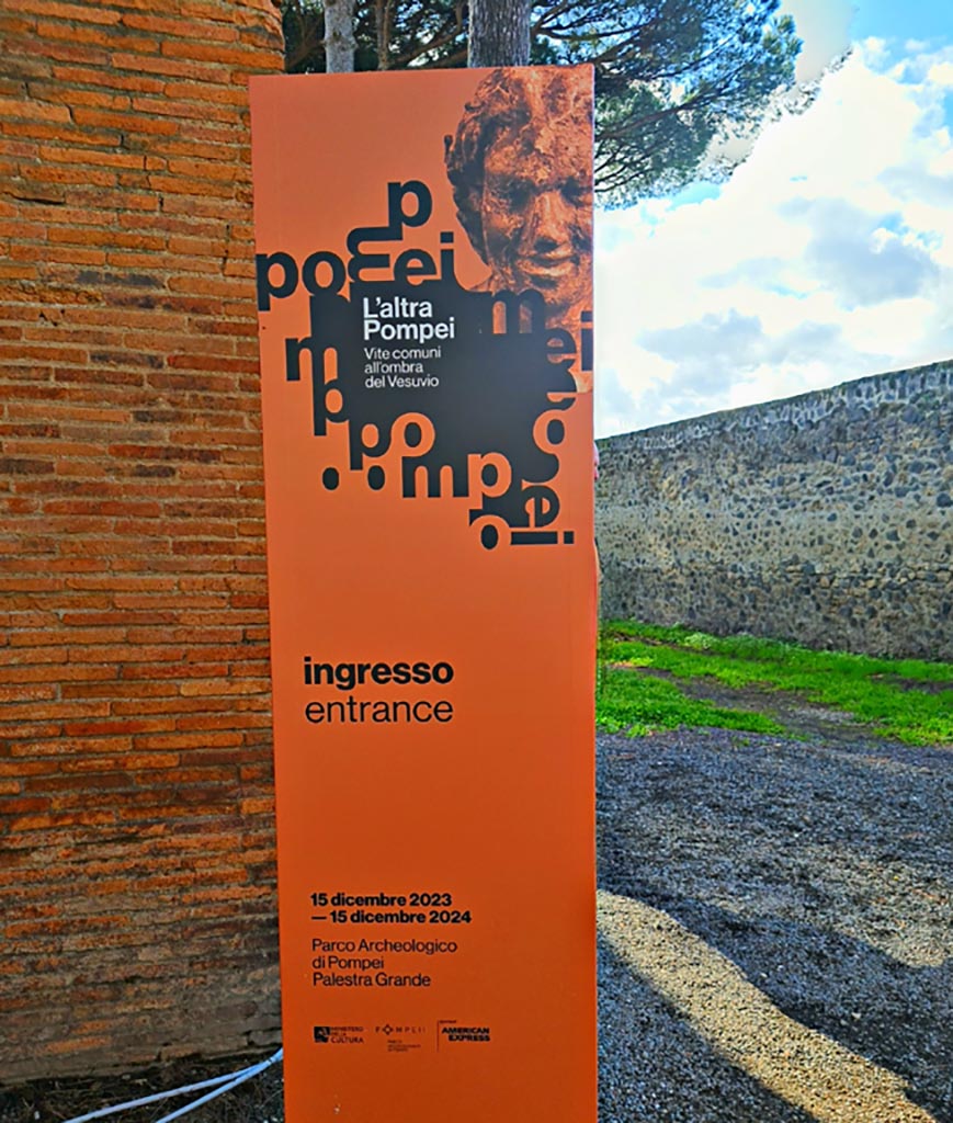 II.7.8 Pompeii. March 2024. Advertisement for exhibition entitled -
“L’altra Pompei, vite comuni all’ombra del Vesuvio” (“The other Pompeii, common lives in the shadow of Vesuvius.”)
From 15th December 2023 until 15th December 2024. Photo courtesy of Giuseppe Ciaramella.
