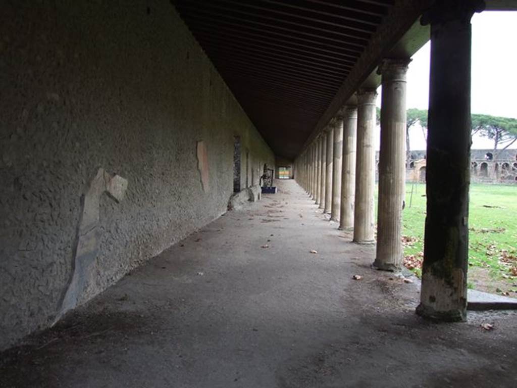 II.7.8 Pompeii. Palaestra. December 2006. Looking east along north portico towards north-east corner.
According to Maiuri –
“The only wall of the portico that, at the moment of the eruption, preserved its pictorial decoration, was the wall of the north portico, the one which, however, was found completely fallen, other than the last short stretch of just over 14 metres at the far north-east corner.
On the other two long walls of the west and south porticos, and the wall on the east side, nothing was seen other than a minimum trace of decoration.”
See Notizie degli Scavi, 1939, (p.184)
