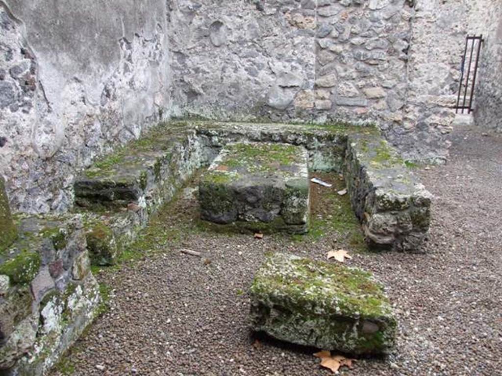 II.8.5 Officina di Sabbatino. December 2007. Three sided stone bench and table in south west corner of atrium area.