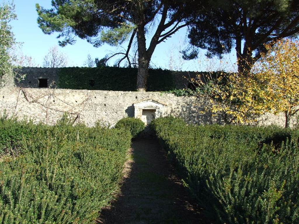 II.8.6 House of the Garden of Hercules. Lararium on east wall of garden.
