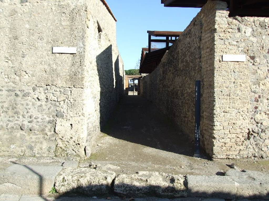 II.9.1 Pompeii (side south wall), on left. Via della Palestra, looking east towards Palaestra. II.8.6, on right.
