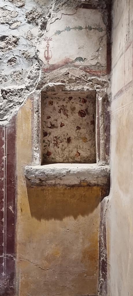 II.9.4 Pompeii. December 2023.
Room 6, floral lararium at east end of north wall. Photo courtesy of Miriam Colomer.