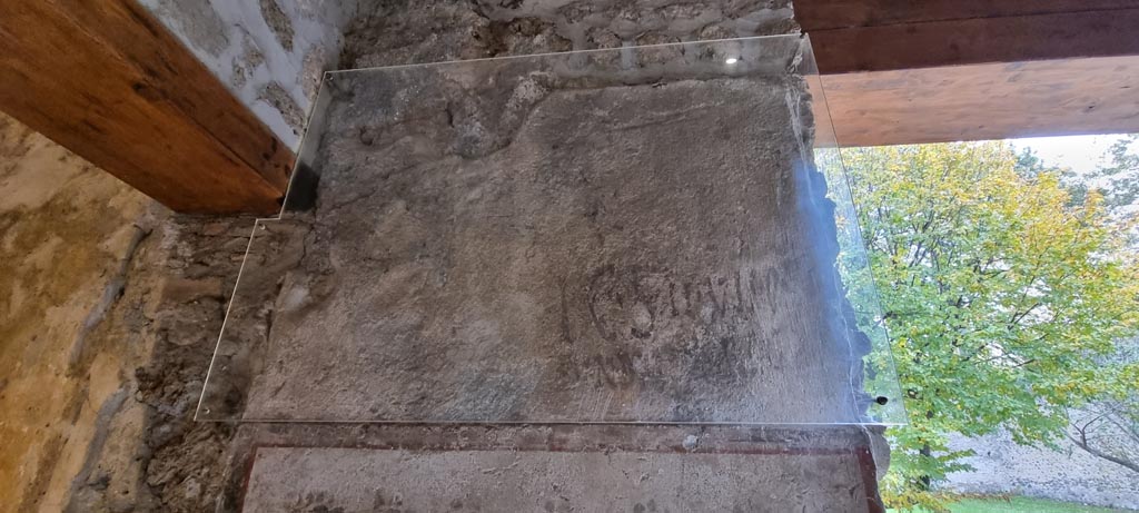 II.9.4 Pompeii. December 2023.
Room 5, detail of inscription on east wall between doorway to room 4, on left, and window to garden, on right. Photo courtesy of Miriam Colomer.
