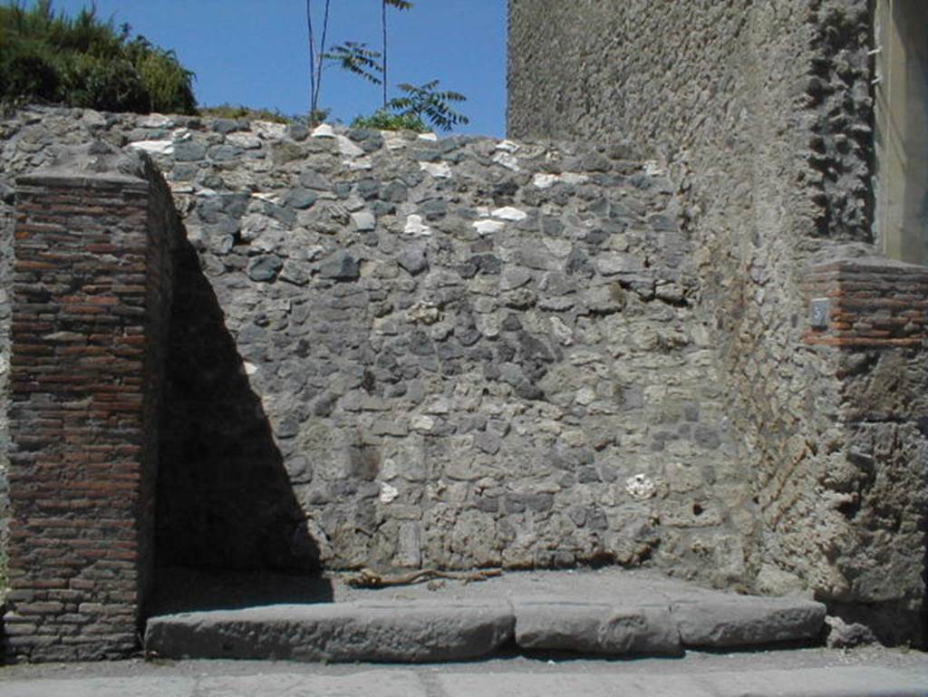 III.3.5 Pompeii. May 2005. Blocked entrance doorway, partly excavated.
According to Garcia y Garcia, a bomb dropped during the bombardment of 19th September 1943 destroyed the façade of this shop.
This led to the disintegration of the pilasters and doorposts of three entrances, (III.3.3, 4 and 5).
Also ruined were the dividing walls and the perimeter wall onto Via dell’Abbondanza for 26 x 5 metres.
In III.3.5 the internal walls were also destroyed.
See Garcia y Garcia, L., 2006. Danni di guerra a Pompei. Rome: L’Erma di Bretschneider. (p.53)