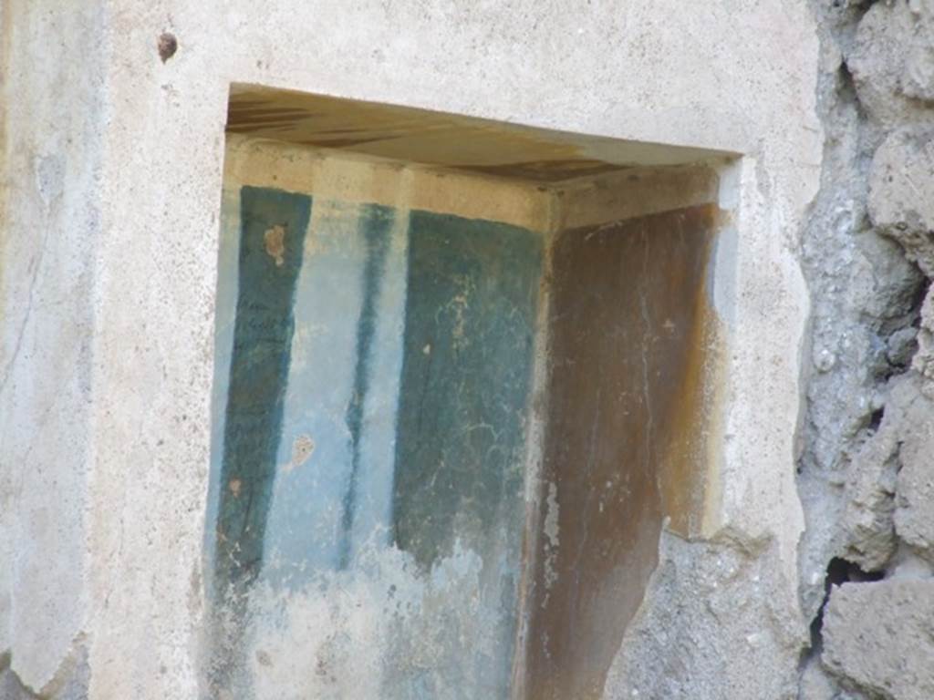 III.4.1 Pompeii. March 2009. Yellow and blue walls inside the niche.
According to Boyce, it had an aedicula façade painted on the wall around it.
Two pilasters supported a white architrave and a blue pediment which was ornamented with a white disc in the centre and surrounded by white cornices.
The side walls within the niche were yellow, the back wall was blue, and the edges white.
See Boyce G. K., 1937. Corpus of the Lararia of Pompeii. Rome: MAAR 14. (p.30, No.65, Pl.1, 6)