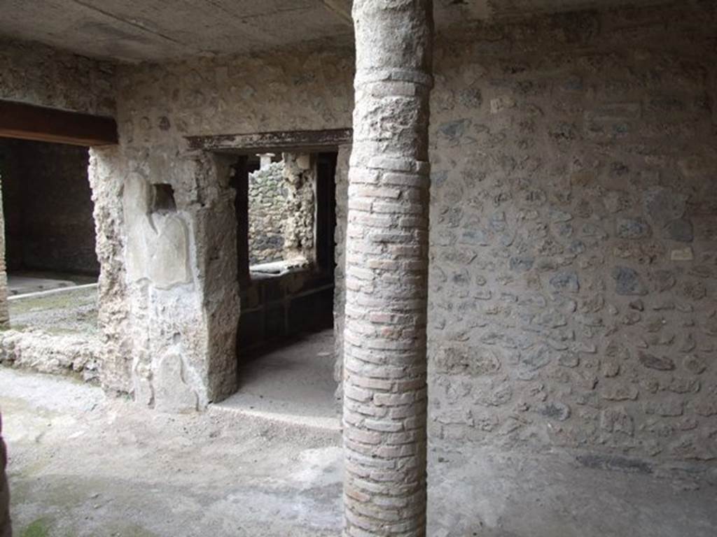 III.4.3 Pompeii. March 2009. Room 12. Courtyard, Looking north to portico area, and door to room 13 with window overlooking garden. On the west side of the doorway, a square hole in the doorpost can be seen. Originally this was covered with glass, and would have contained a lamp for lighting the passageway at night. See Jashemski, W. F., 1993. The Gardens of Pompeii, Volume II: Appendices. New York: Caratzas. (p.102).
