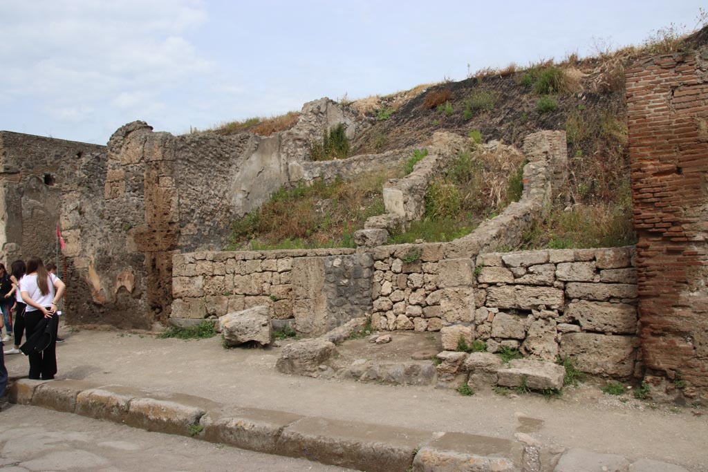 III.6.3 Pompeii, on left. May 2024. Looking north-west towards entrance to shop with doorway threshold.
In the centre, is the entrance doorway/corridor into the unexcavated Casa di M. Satrius at III.6.4, with rear west upper walls showing.
Photo courtesy of Klaus Heese