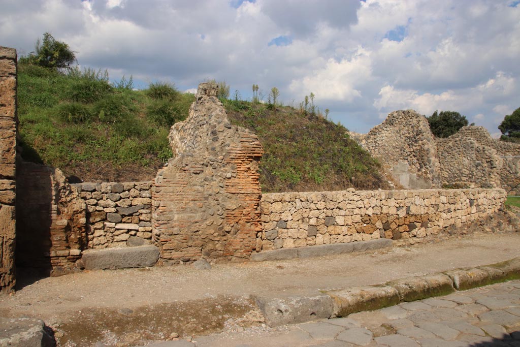 III.7.5 Pompeii, centre right. October 2022. Entrance doorway, with grey lava doorway threshold, on north side of Via dell’Abbondanza.
On the left is the entrance doorway belonging to III.7.4. Photo courtesy of Klaus Heese