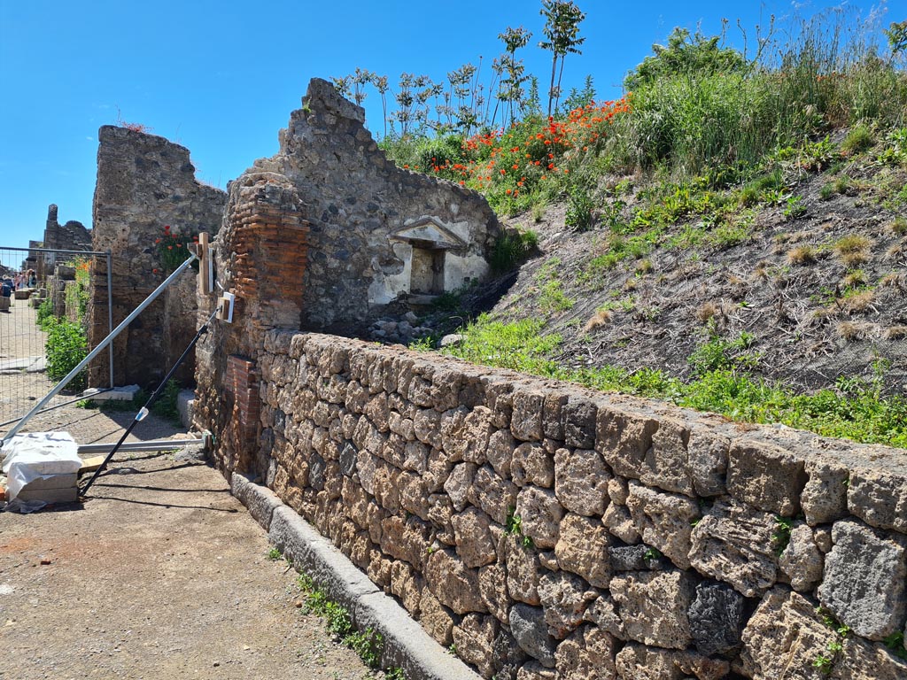 III.7.5 Pompeii. May 2024.
Looking towards west side of entrance threshold, with niche in west wall of shop-room. Photo courtesy of Klaus Heese.