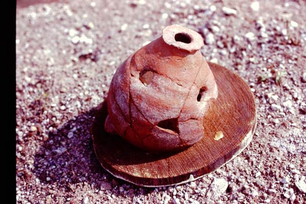 III.7 Pompeii. 1976. Broken planting pot with one hole in the bottom and three holes in its side. Photo by Stanley A. Jashemski.
Source: The Wilhelmina and Stanley A. Jashemski archive in the University of Maryland Library, Special Collections (See collection page) and made available under the Creative Commons Attribution-Non Commercial License v.4. See Licence and use details. J76f0471