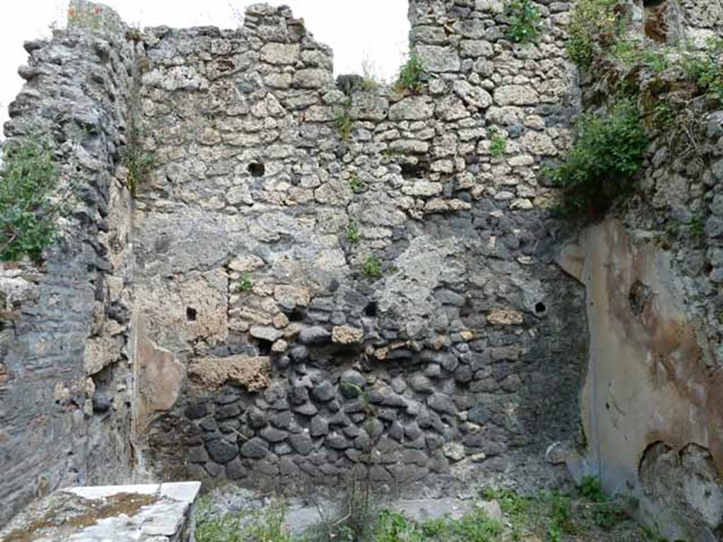 III.8.8 Pompeii. May 2010. East wall of bar, with a window from an upstairs room. According to Sogliano, the walls were plastered with a background of dark-yellow, divided by vertical bands of green. The base of the walls were dark green. The east wall was the best preserved and showed three panels. The central panel contained a painting of a peacock pecking on a seedling. The two side panels each had a painting of a griffin, facing each other. To the left of the griffin in the right panel, a painting of Mercury was seen but which was largely faded. See Notizie degli Scavi di Antichità, 1905, (p.274).