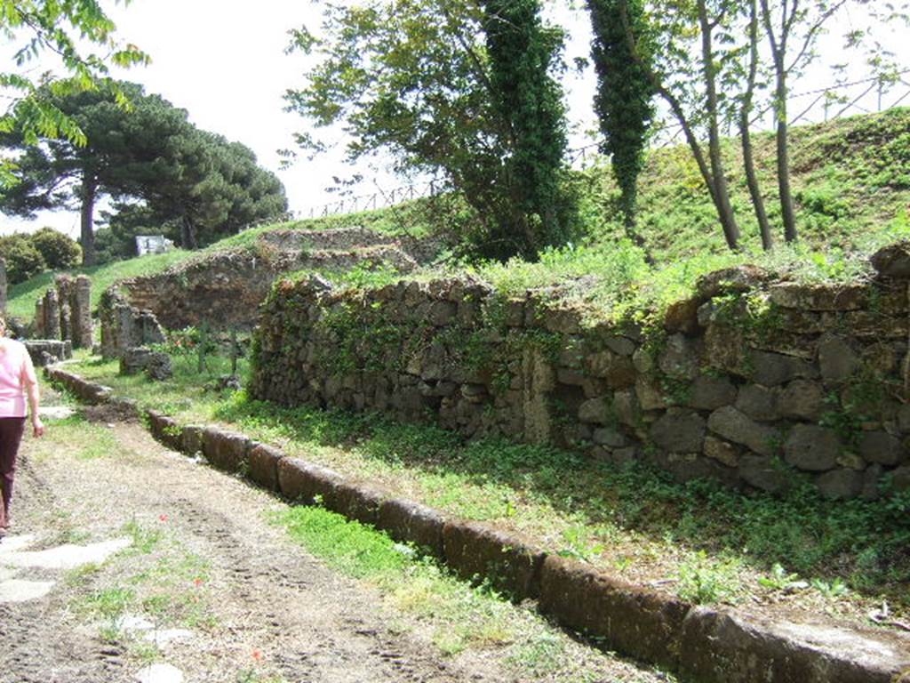 III.10.3 Pompeii. May 2006. Looking east along Via Nola, along the front wall of the insula.