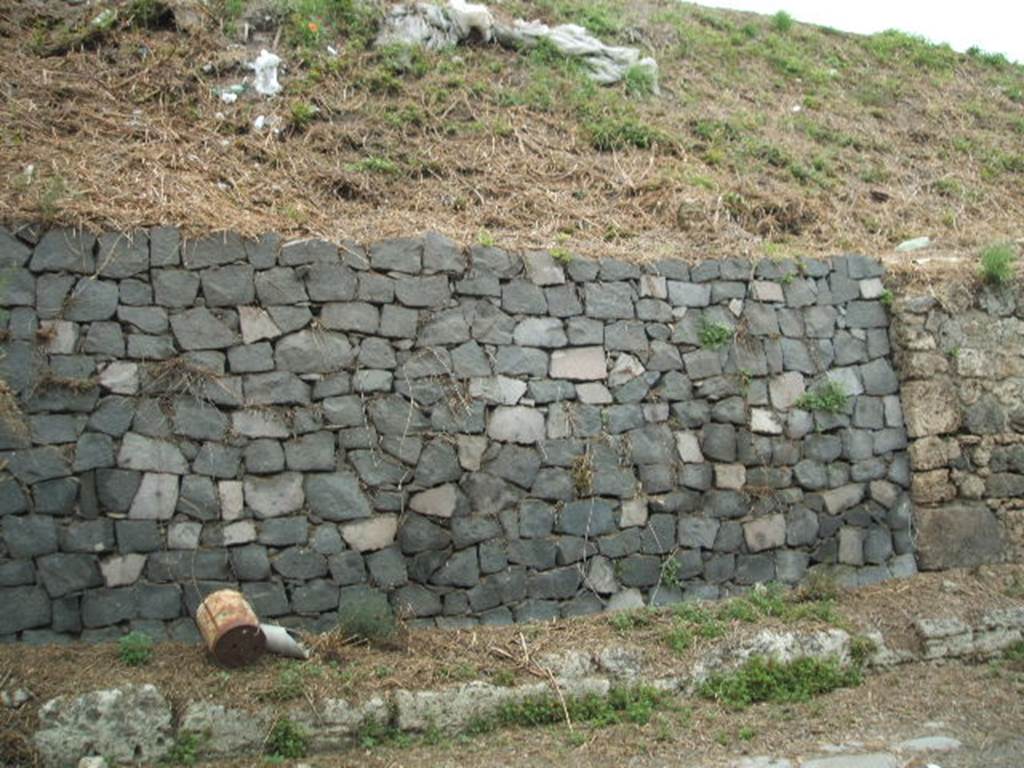 IV.1.b and IV.1.c Pompeii. May 2005. Site of entrances.
The doorways that used to front onto the northern side of Via Nola, forming Regio IV, have now been filled in as a wall to keep the earth bank back from the road. It is very difficult to find the exact position of these doorways and link them to any site plan.