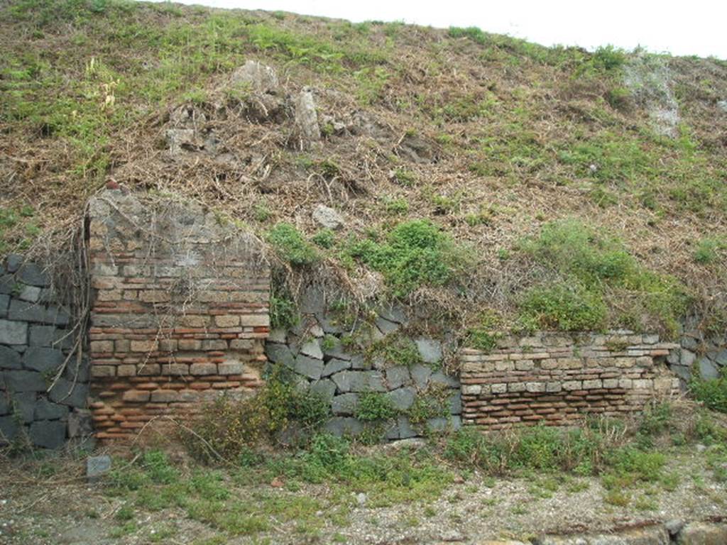 IV.1.f Pompeii. May 2005. Entrance, filled in with grey stones.
The doorways that used to front onto the northern side of Via Nola, forming Regio IV, have now been filled in as a wall to keep the earth bank back from the road. It is very difficult to find the exact position of these doorways and link them to any site plan.