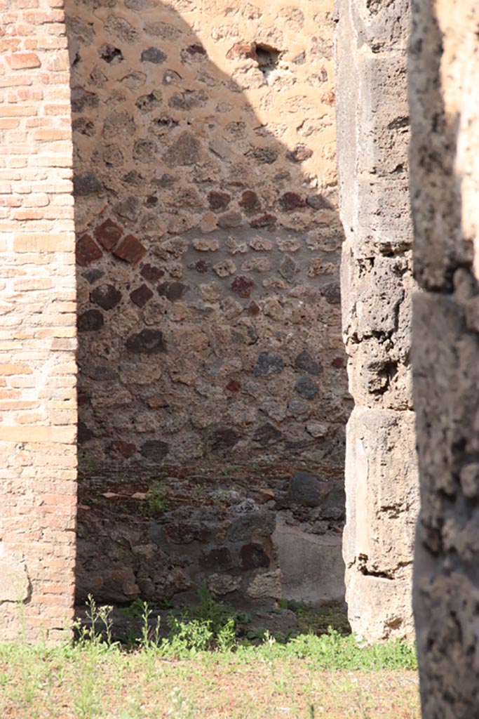 V.1.3 Pompeii. October 2023.
Looking through doorway towards west side with remains of bench. Photo courtesy of Klaus Heese.