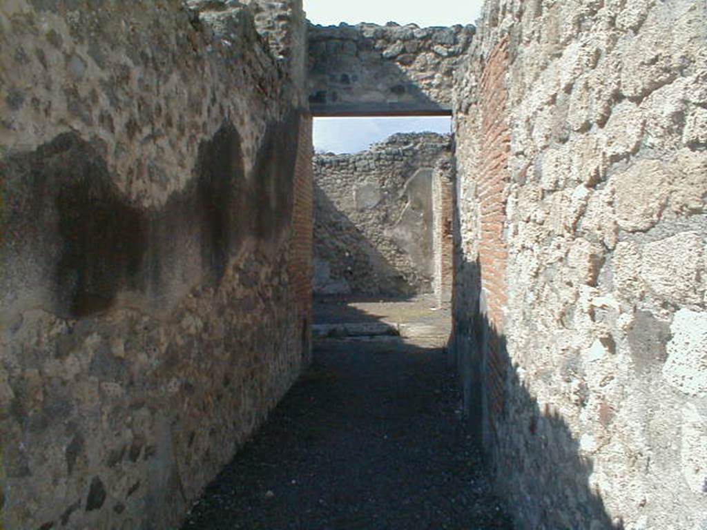 V.1.3 Pompeii. September 2004. Entrance corridor, looking north across atrium towards tablinum.
According to Niccolini –
“This house was preceded by the usual entrance corridor, which leads to the atrium with an impluvium in the centre, there are three cubiculae on the left side of the atrium, and on the right, a passage leading into the following house (at V.1.7) and a very large room.
Facing (on the north side) we find the tablinum with a triclinium on its right, surrounded internally by large masonry seating, which could have been used as the triclinium couches, and to the left from a small corridor going up two steps you reach the kitchen with nearby latrine.
The tablinum, the triclinium, the corridor and kitchen were excavated in 1875.”
See Niccolini F, 1896. Le case ed i monumenti di Pompei: Volume Quarto: Part 1. Napoli, (p.8, Appendice, Nuovi Scavi dal 1874 a tutto il 1882)