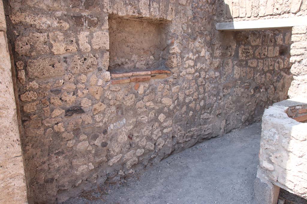 V.1.5 Pompeii. September 2021.
Looking towards west wall with square niche/recess and doorway into rear room. Photo courtesy of Klaus Heese.
