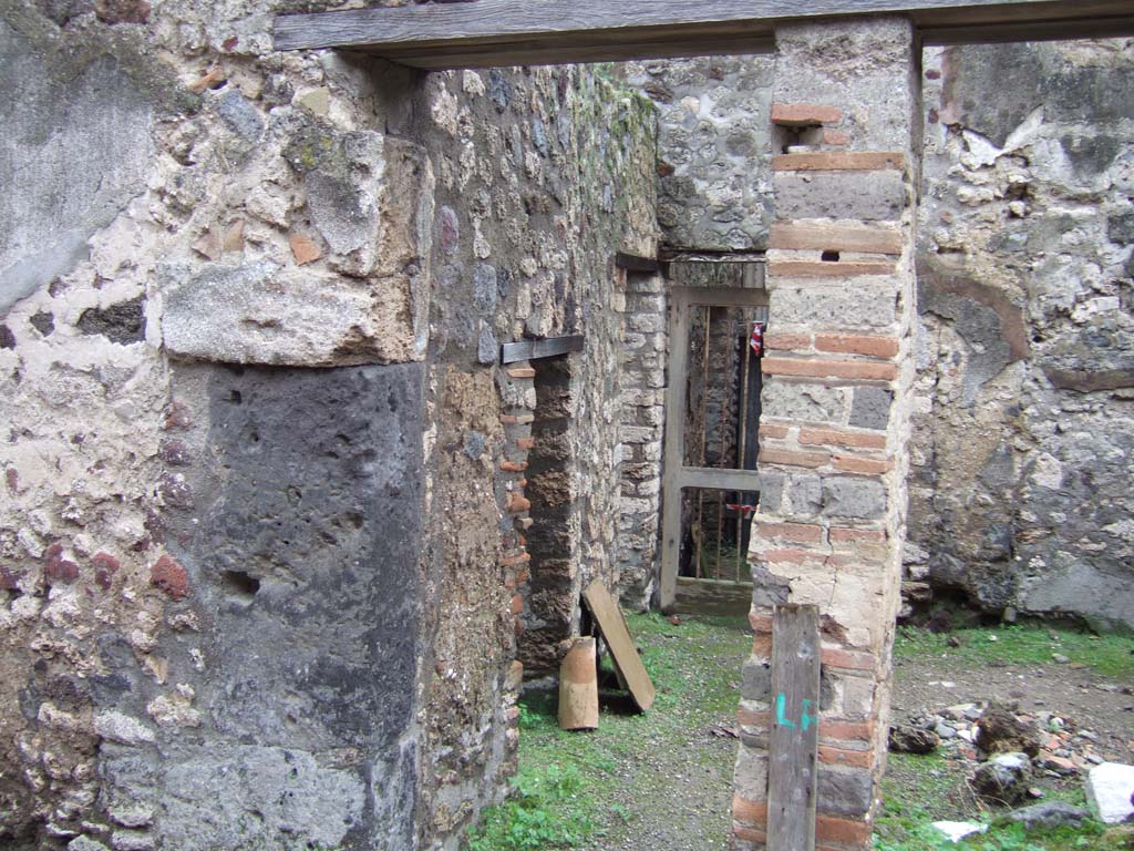 V.1.11 Pompeii. December 2005. Entrance doorway, looking south.
In the east wall, (on the left), are two doorways –
the nearest into a latrine, the second into the kitchen with a hearth against the east wall and the lararium niche above it.