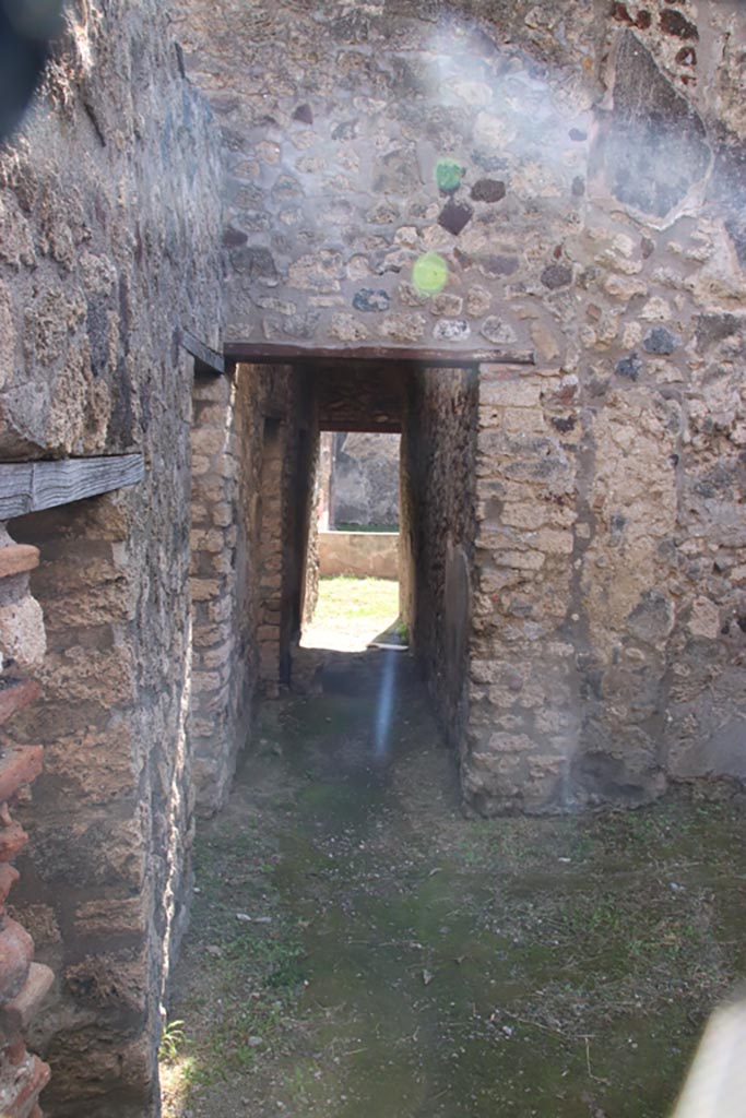 V.1.11 Pompeii. October 2023.
Looking south from entrance doorway towards doorway into corridor leading into V.1.18 peristyle.
Photo courtesy of Klaus Heese.