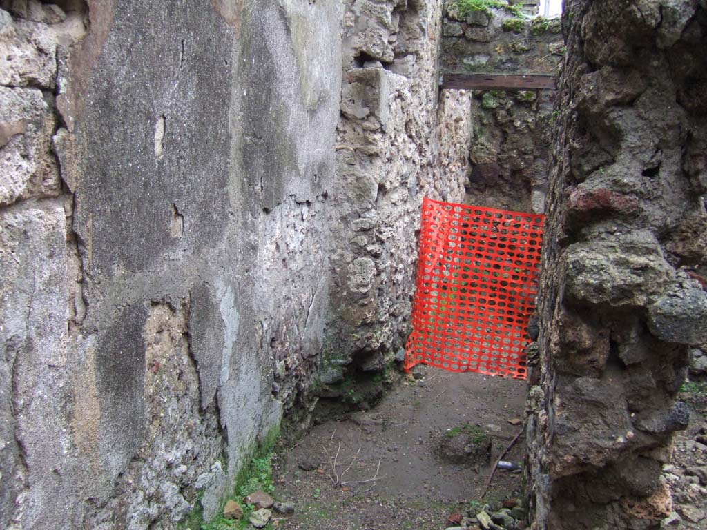 V.1.11 Pompeii. December 2005. Looking west along corridor, towards room with niche on south wall, according to Boyce.
This niche was ruined but had traces of painting visible on its walls.
See Boyce G. K., 1937. Corpus of the Lararia of Pompeii. Rome: MAAR 14. (p.32, no.76).
In this same room, in the latrine in the north-east corner, Sogliano reported a painting of Vesta.
See Boyce G. K., 1937. Corpus of the Lararia of Pompeii. Rome: MAAR 14. (p.32, no.77)
See Sogliano, A., 1879. Le pitture murali campane scoverte negli anni 1867-79. Napoli: (p.16, no.43)