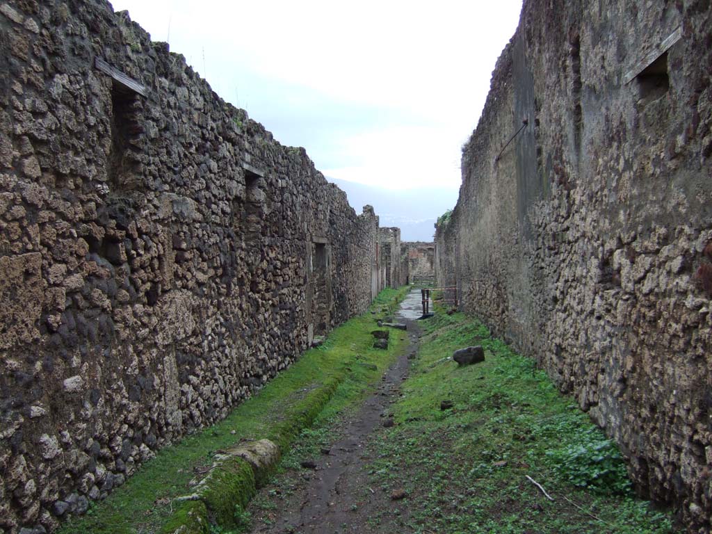 V.2 Pompeii, on left. December 2005. Vicolo di Cecilio Giocondo, looking south. Side wall of V.1.11, on right.