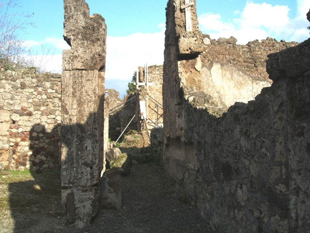 V.I.13 Pompeii. December 2004. Looking east towards rear.
According to Packer, - At the rear, on the north side of the corridor, would have been another room, probably used for dining.
This room originally had a marble threshold, and also a window in its north wall overlooking the Vicolo delle Nozze d’ Argento.
This room originally would have had decorations in the Fourth Style on a white background, with a still extant red dado (north wall).
To the east of that room would have been an open courtyard which had suffered from the 1943 bombing.
The stairs to the upper floor would have been against the north wall of the courtyard, running up towards its west end with a latrine beneath in the north-west corner.
In the north-east corner, in antiquity, would have been a second rear room, also lit by a window in the north wall, but its west and south walls were demolished to enlarge the courtyard.
The kitchen stands behind the courtyard with a large hearth in the north-west corner, and one (of the formerly two) masonry supports for a table in the south-east corner.
See - Packer, Jim: Inns at Pompeii: a short survey. In Cronache Pompeiane, IV, 1978, (p.40-42).
