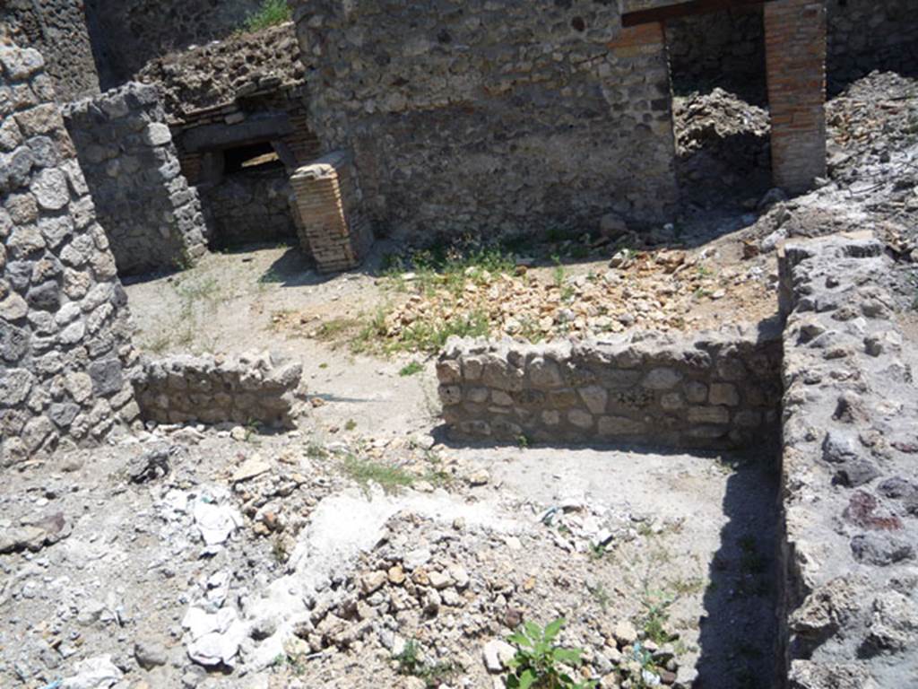 V.1.15 Pompeii. July 2008. Looking towards south wall with doorway into open tablinum, and across to larger oven. Photo courtesy of Jared Benton.