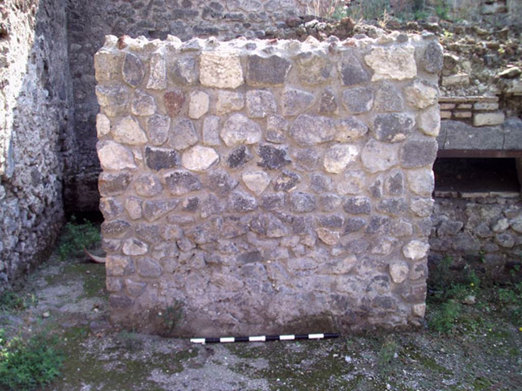 V.1.15 Pompeii. September 2009. Looking south at east end of oven.
The doorway to the kitchen and latrine in the south-east corner of the bakery is on the left. Photo courtesy of Jared Benton.
According to Boman and Nilsson –
“This room is a rectangular room with a single entrance facing the peristyle-viridarium area.
Based on the installations found inside the room, it presumably served as a combined kitchen and toilet.
The doorway has a lava threshold for a door opening inwards.
Features in the room are a latrine with cess pit, a hearth (presumably of earlier date) and in the SE corner, a narrow quarter-circular bench.”
See The Swedish Pompeii Project (room i)