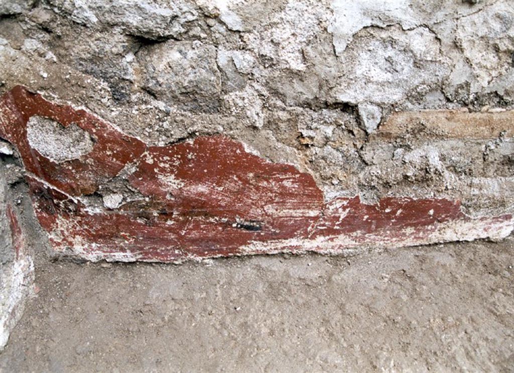V.1.15 Pompeii. Not dated.
West wall in south-west corner, detail of remaining red-coated plaster decoration.
Photo by Henrik Boman.
Photo courtesy of the Swedish Pompeii Project.