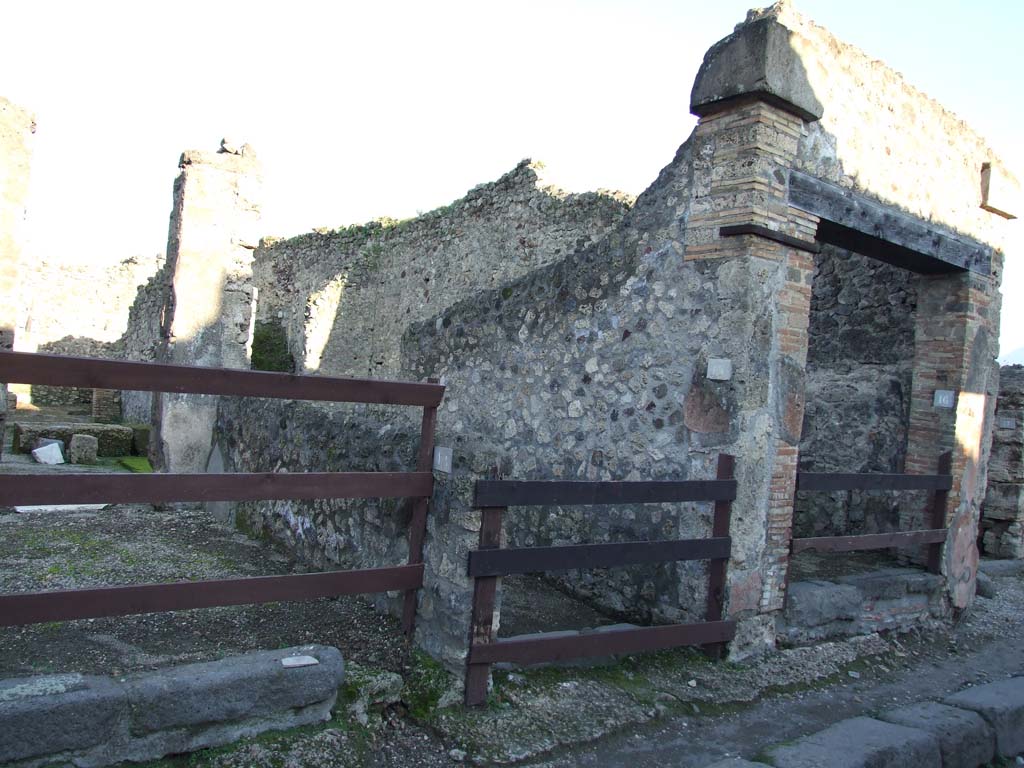 V.1.15 Pompeii. December 2006. Entrance in centre. V.1.14 on left and V.1.16 on right.
This area was badly hit by the bombing of the night of 16th September 1943.
The north-east part was badly hit, destroying four rooms and a good part of the northern perimeter wall.
Another bomb partly destroyed the road near the entrance doorway.
See Garcia y Garcia, L., 2006. Danni di guerra a Pompei. Rome: L’Erma di Bretschneider. (p.61)