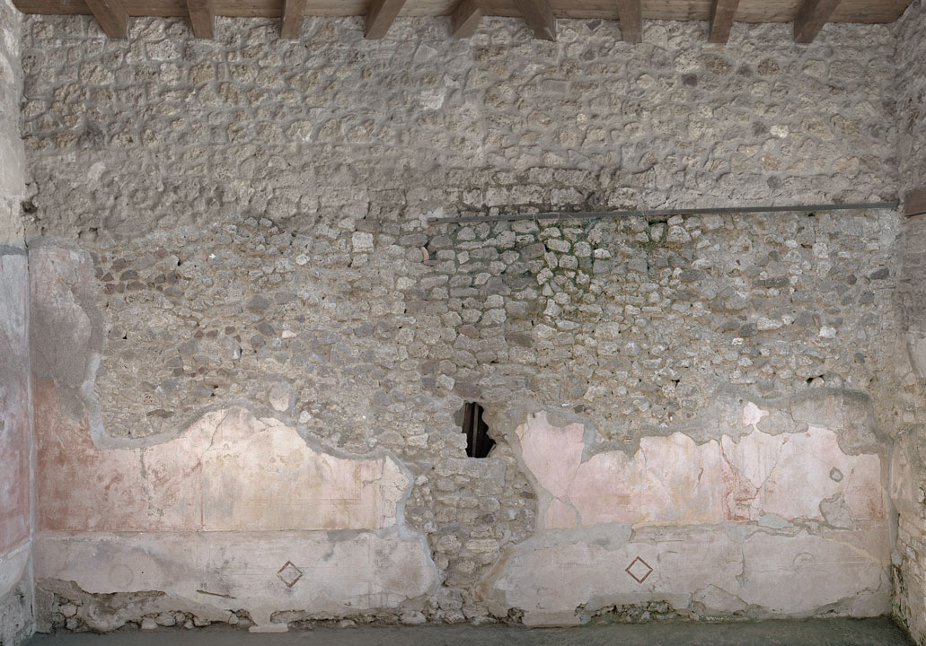 V.1.18 Pompeii. 2012. Room “p”, oecus, east wall. Photo by Hans Thorwid.
“East wall in 2012.
Restored parts of the wall photographed and merge with the lower part and floor line of earlier photos from 2005-07.”
Photo and words courtesy of The Swedish Pompeii Project.
According to Schefold –
On the east (right) wall was a painting of Polyphemus and Galatea.
See Schefold, K., 1957. Die Wände Pompejis. Berlin: De Gruyter. p. 65.