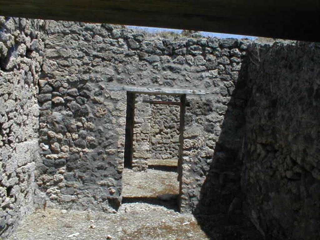 V.1.20 Pompeii. May 2005. Doorway from rear room, towards kitchen, small garden and cubiculum. According to Jashemski - “The tiny garden (a) excavated in 1875, in the rear north-east corner of this small shop-house wedged in between 2 large houses was little more than a light well enclosed by a low wall with a gutter at the base; along the inside of the gutter, according to Viola, there was a narrow planting bed. The kitchen (b) opened onto the garden."
See Mau, Bdl (1877), p.18
See Viola, Gli Scavi di Pompei dal 1873 al 1878, p.28.
See Jashemski, W. F., 1993. The Gardens of Pompeii, Volume II: Appendices. New York: Caratzas. (p.108)