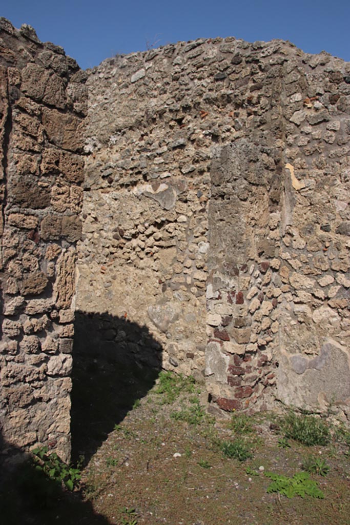 V.2.12 Pompeii. October 2023.
Doorway to rear room in north wall of shop-room. Photo courtesy of Klaus Heese.