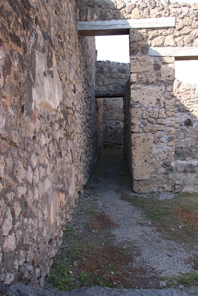 V.2.13 Pompeii. October 2022.
Corridor to rear kitchen on west side of north wall of bar-room. Photo courtesy of Klaus Heese.