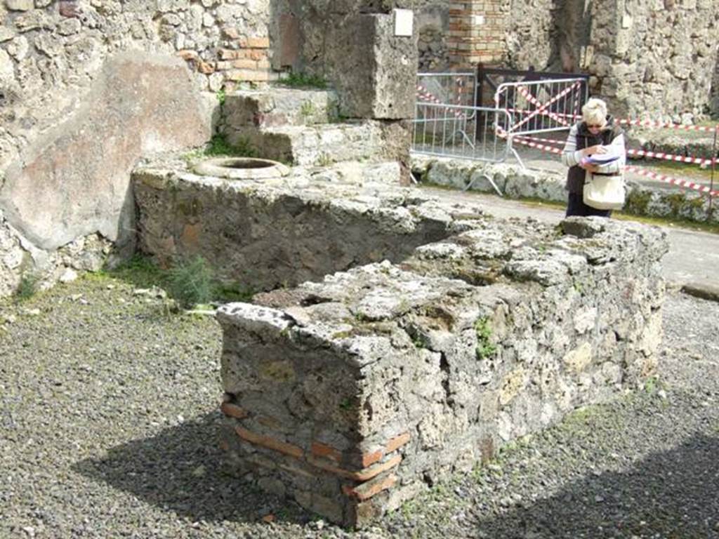 V.2.13 Pompeii, March 2009. Two sided counter, originally with four urns and a hearth. Looking south east.