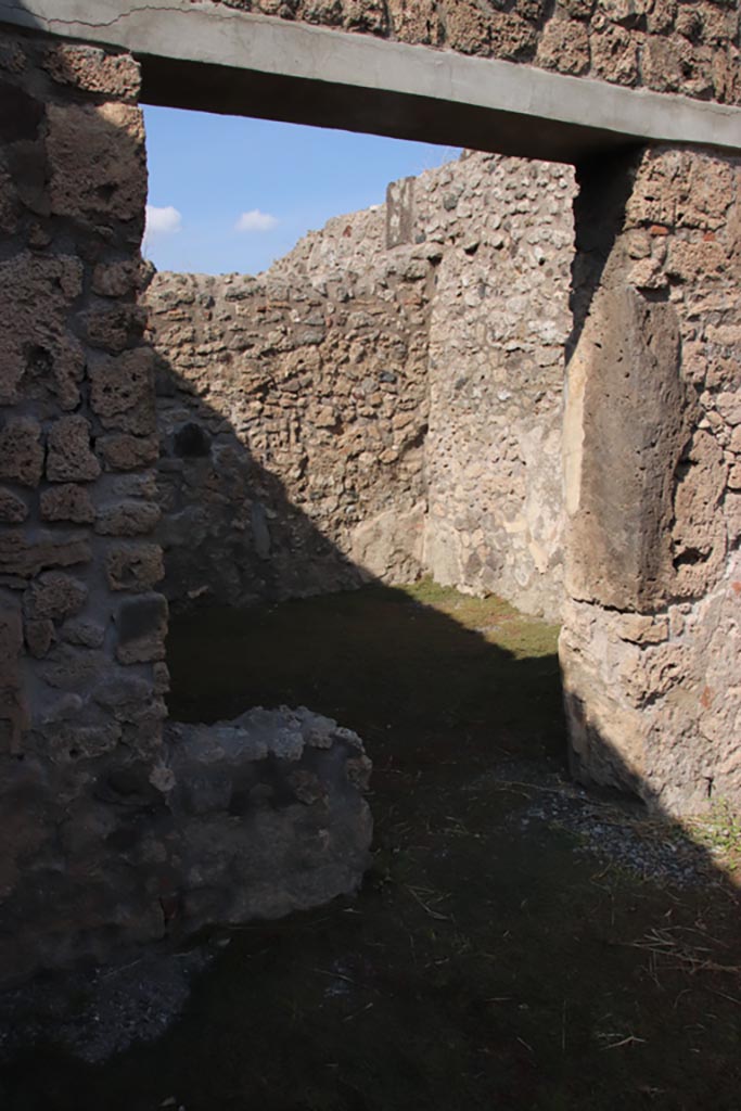 V.2.13 Pompeii. October 2022.
Looking north-east through doorway of rear room in north wall of bar-room. Photo courtesy of Klaus Heese.