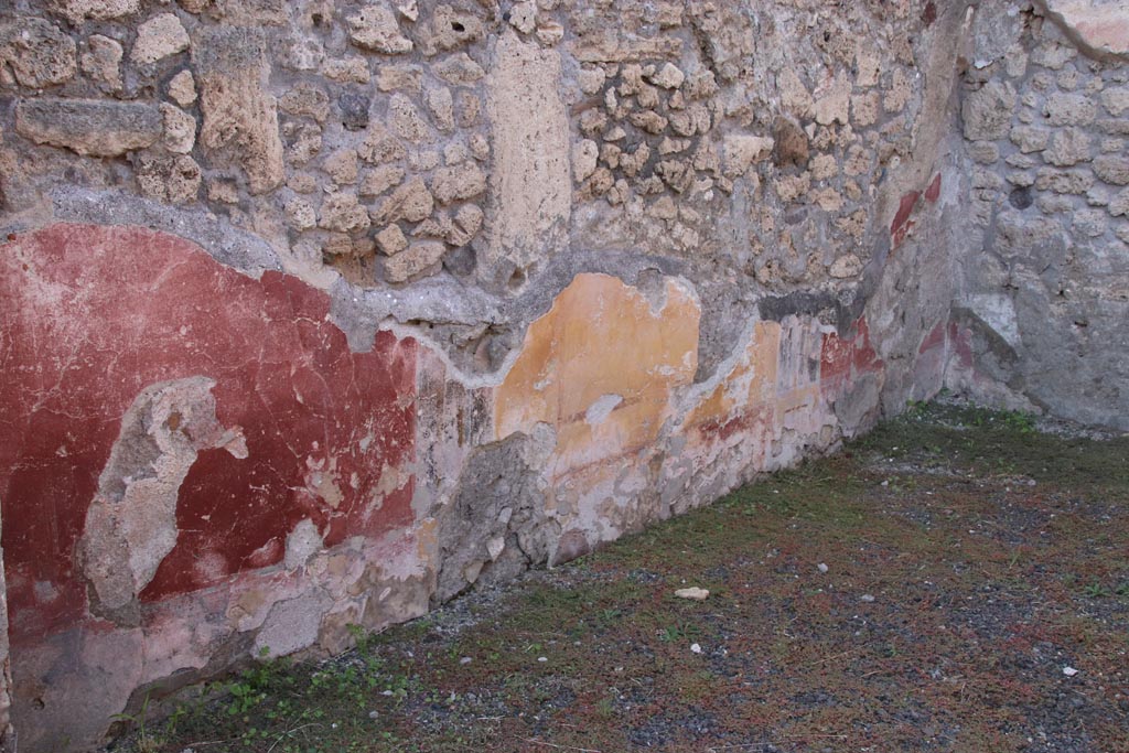 V.2.14 Pompeii. October 2022.
West wall of rear room with remains of yellow central panel, and the two red side panels. Photo courtesy of Klaus Heese.