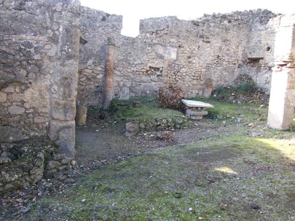 V.2.15 Pompeii. December 2007. Peristyle, looking west at remains of triclinium.
According to Jashemski –
“There was a narrow portico on the east supported by three columns which were joined by a low wall; the wider portico on the north in addition to the corner column was supported by a pillar. Between the corner column and the pillar stood a rectangular marble table mounted on two supports.
On the west, the garden was enclosed by a low wall which was shaped to leave room for the cistern-opening in the south-west corner.
There was a gutter along the outer edge of the garden.
Built against the west wall was a masonry triclinium (l. medius, 4.20m; l . imus and l. summus, 3.30m; a rectangular table between the couches 0.93 x 0.57m).
It was shaded by a pergola supported by two columns in front, two engaged columns at the rear.
The columns were covered in yellow stucco on which vines were painted.
The holes in which the little poles which supported the vines were inserted are still visible.”
See Jashemski, W. F., 1993. The Gardens of Pompeii, Volume II: Appendices. New York: Caratzas. (p.111).