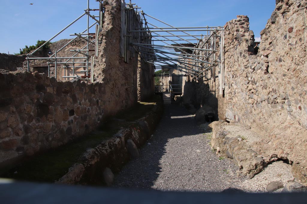 Vicolo dei Balconi, Pompeii. October 2022. Looking north from junction with Via di Nola.
V.2.20 Pompeii is centre left, lit by sunlight. V.2.21 is on the left behind V.2.20, in line with the ramp in the roadway.
Photo courtesy of Klaus Heese.