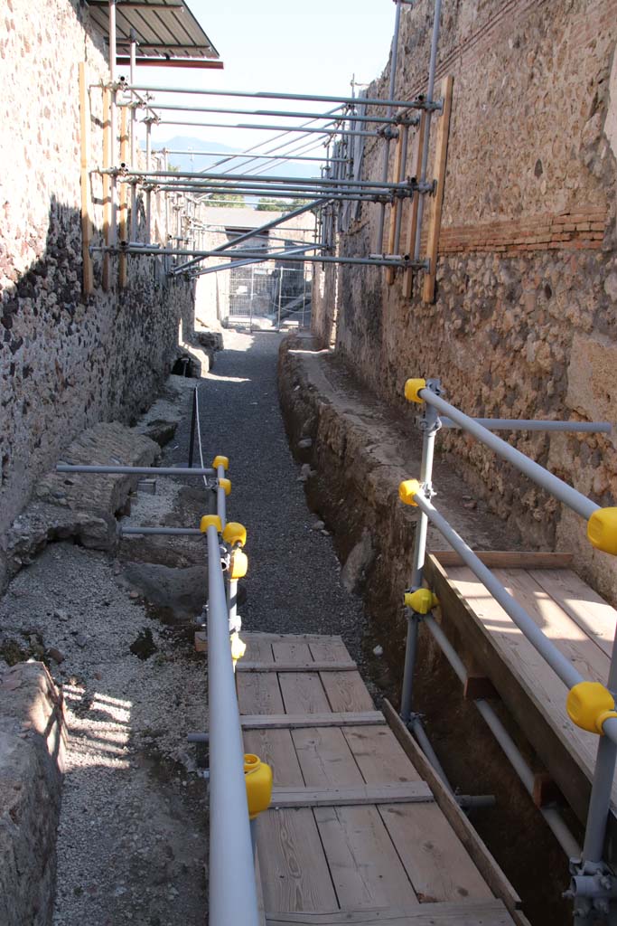 Vicolo dei Balconi, Pompeii. September 2021. Looking south between V.3, on left and V.2, on right.
The entrance doorway to V.2.21 is on the right, where the sunlight is shining onto the planking.
Photo courtesy of Klaus Heese.
